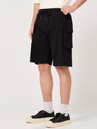Person wearing black cargo shorts on a white background