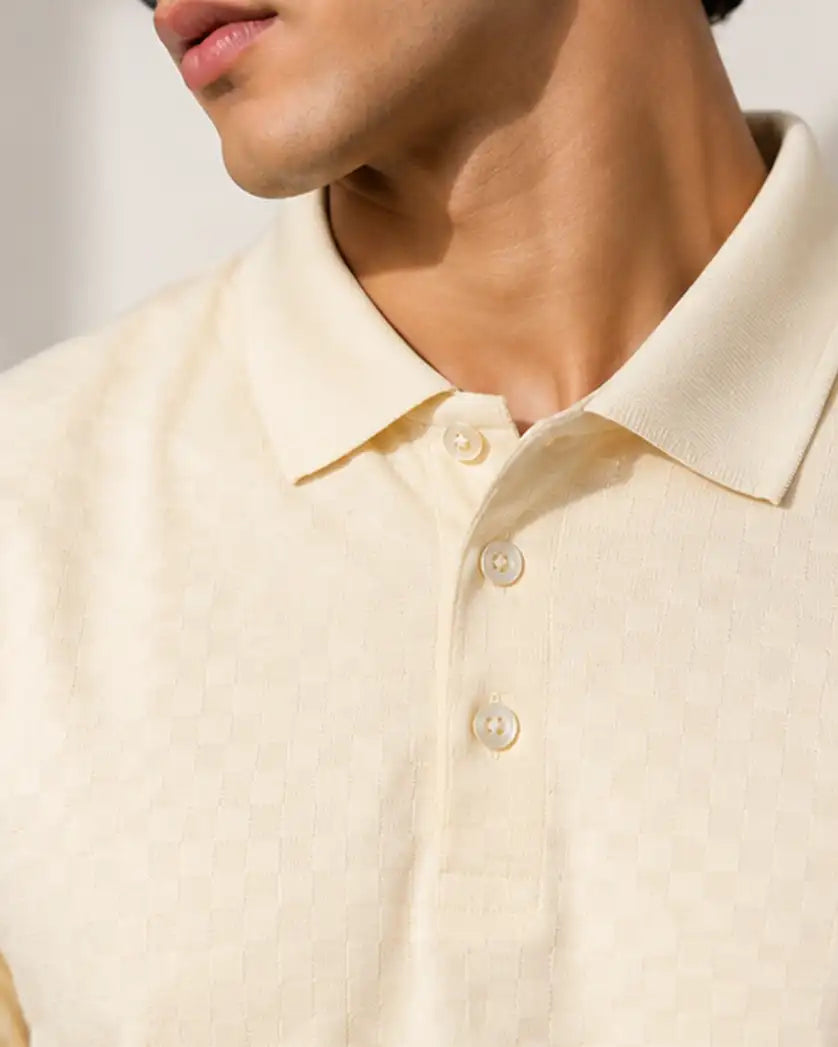 Close-up of a man wearing cream polo shirt